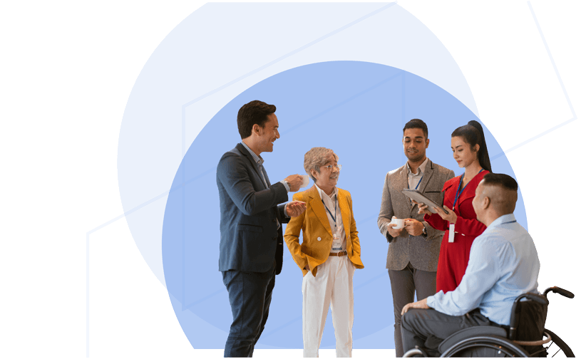 Five professionals discussing together, including a wheelchair user, in a collaborative setting.